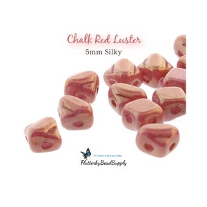 May include: Chalk Red Luster beads, 5mm silky, in a variety of shapes. The beads are a mix of red and pink with a glossy finish. The text "Chalk Red Luster" and "5mm Silky" is visible in the image. The logo for FlutterbyBeadSupply is also visible.