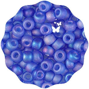 May include: A close-up of a pile of small, iridescent blue glass beads. The beads are round and have a slightly frosted finish.