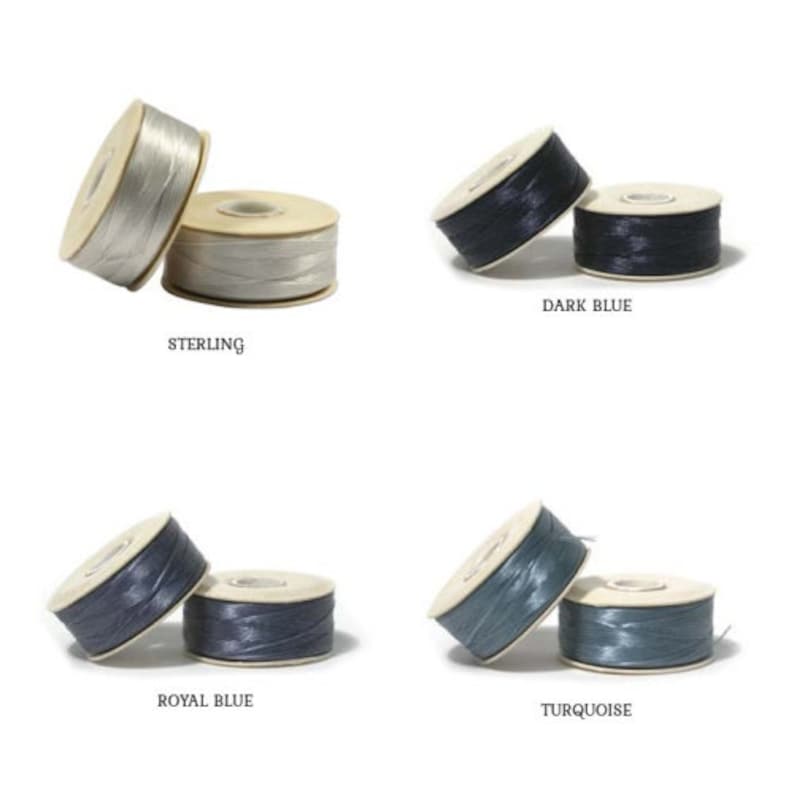May include: Four spools of waxed linen thread in various colours: sterling, dark blue, royal blue, and turquoise. Each spool is labelled with its colour name. The thread is wound around a cardboard core.