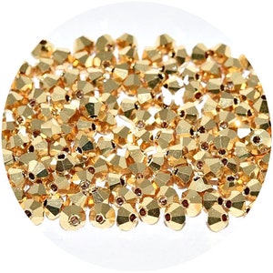 May include: A large quantity of gold-colored faceted glass beads. The beads are small and have a round shape.