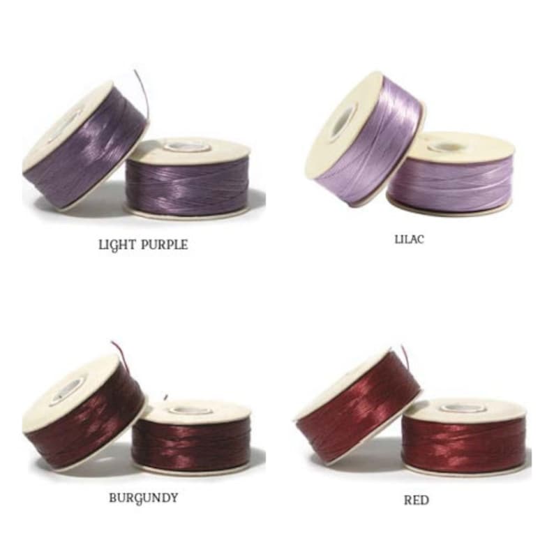 May include: Four spools of coloured thread in light purple, lilac, burgundy, and red. Each spool is paired with a matching, smaller spool. The text on the image reads "LIGHT PURPLE", "LILAC", "BURGUNDY", and "RED".