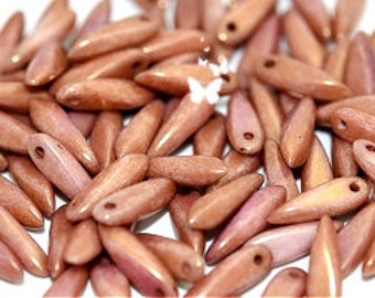 May include: A pile of small, light brown, pointed beads with a hole at the top. The beads have a slightly iridescent finish.