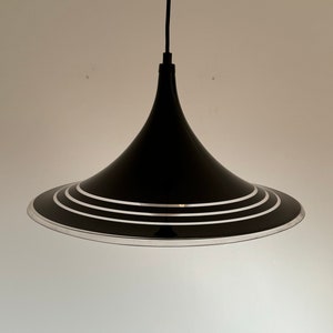 May include: Black pendant light with a wide, cone-shaped shade featuring three silver rings around the bottom edge.