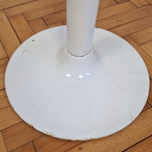 May include: White metal table base with a round, wide base and a tall, slender column.