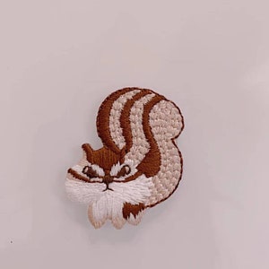 May include: Embroidered brown and white squirrel patch with a fluffy tail.