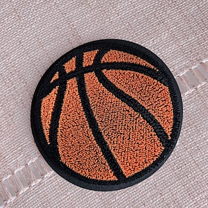May include: A black and orange embroidered patch shaped like a basketball.