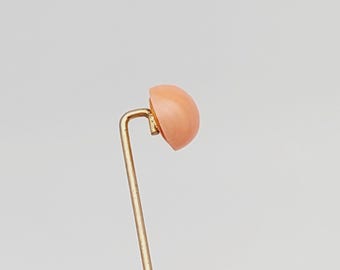 May include: A gold pin with a peach-colored coral cabochon.