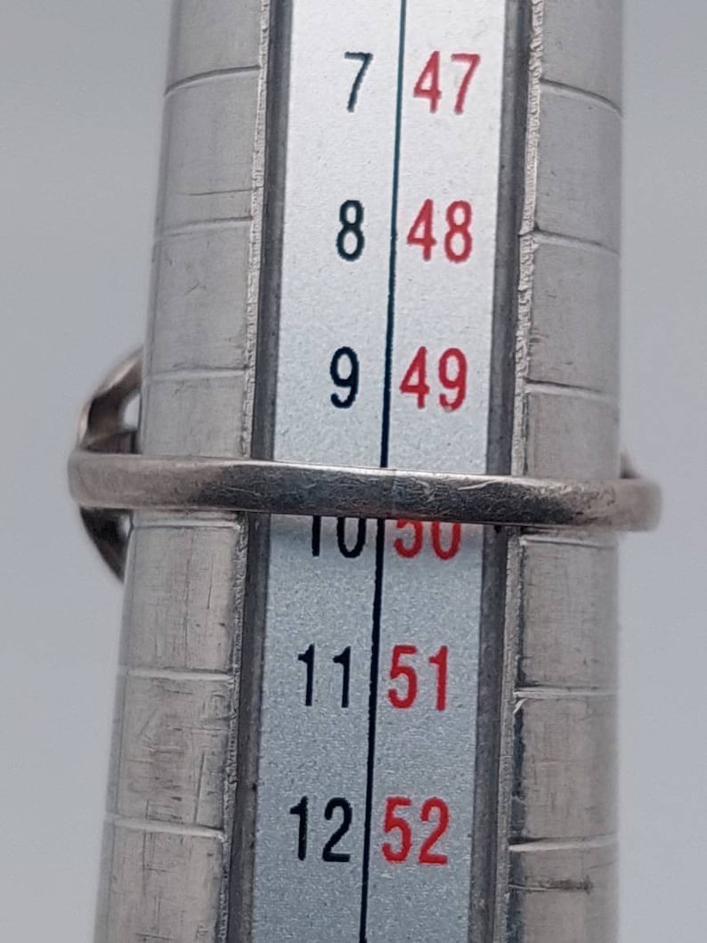 May include: A silver ring sizing tool with numbers 7 through 12 and corresponding sizes 47 through 52.