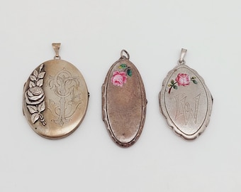 May include: Three antique silver lockets. The first is oval with a rose and leaf design. The second is oval with a pink rose. The third is oval with a rose and the letter "W".