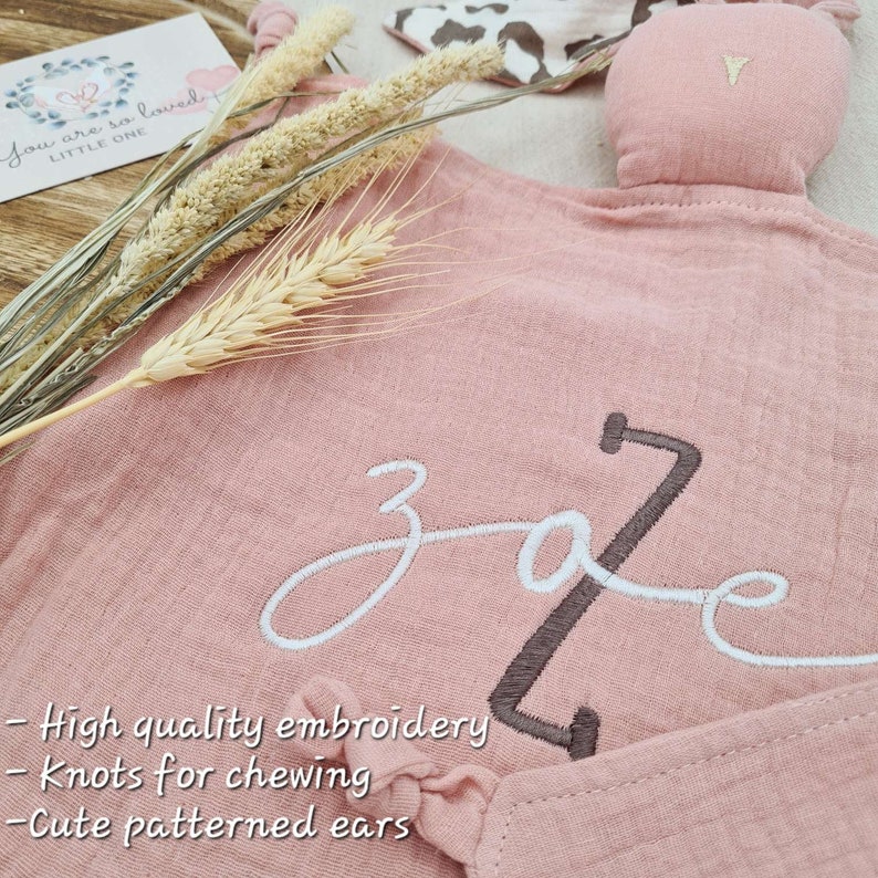 Warm pink baby comforter blanket with embroidered baby name and animal print ear pattern