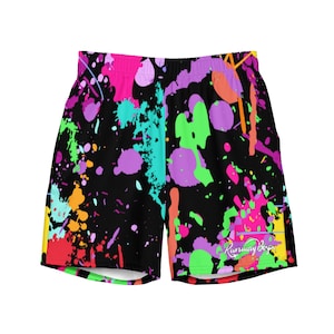 Puede incluir: Shorts deportivos negros con un diseño de salpicaduras de pintura de colores. Los shorts tienen una cintura elástica blanca y el texto "Runaway Boys" está impreso en la pierna derecha.