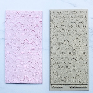 May include: A pink and beige silicone mold with a repeating pattern of overlapping arches and circles. The mold is labeled "TTLA-874" and "cooltools".