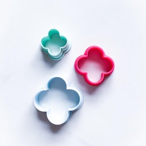 以下が含まれることがあります： 水色、ピンク、ターコイズ色のクローバー型クッキーカッター3個セット。プラスチック製で、白い面に配置されています。ベーキングやクラフトに最適です。直径約5cmです。