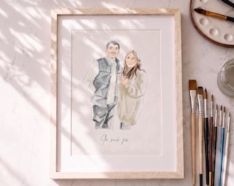 May include: A framed watercolor portrait of two people standing side by side, with the text "She said yes" written in cursive below them. The person on the left wears a vest and the person on the right wears a sweater. The artwork is in a light wood frame.