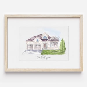 K&ouml;nnte beinhalten: Ein Aquarellbild eines zweist&ouml;ckigen Hauses mit braunem Dach, wei&szlig;en W&auml;nden und einem gr&uuml;nen Rasen. Das Haus hat eine Garage und eine Veranda. Das Bild ist in einem hellen Holzrahmen gerahmt und enth&auml;lt den Text "Our First Home".