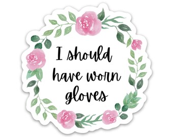 Può includere: Un adesivo fustellato con una ghirlanda floreale ad acquerello con rose rosa e foglie verdi che circonda il testo nero che recita, I should have worn gloves. L'adesivo ha un bordo bianco e un design con bordi smerlati.