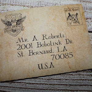 May include: A vintage-style envelope with an owl logo and the text "Owl Post" in the upper right corner. The envelope is addressed to "Mr. A. Roberts, 2001 Bobolink Dr., St. Bernard, LA 70085, USA".