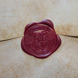 May include: A red wax seal with the Hogwarts crest and the words "Hogwarts School of Witchcraft and Wizardry" around it.