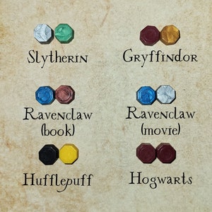 May include: A set of wax seals representing the Hogwarts houses: Slytherin (silver and green), Gryffindor (red and gold), Ravenclaw (blue and silver), Hufflepuff (black and yellow), and Hogwarts (maroon).