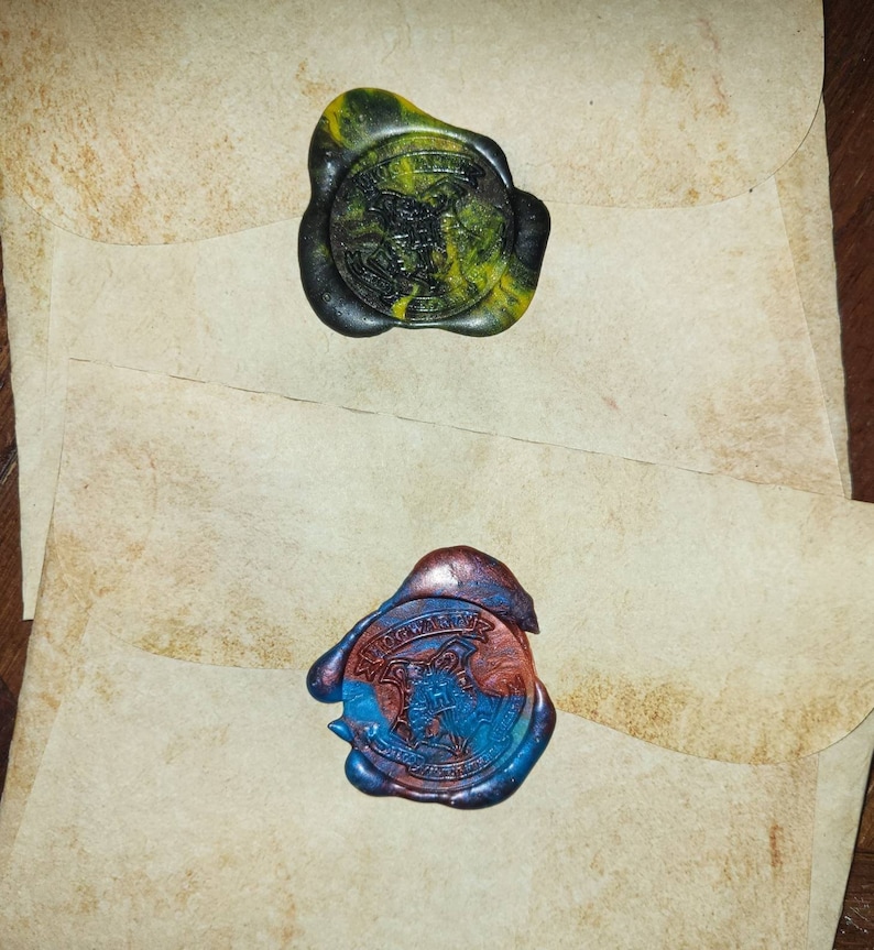 May include: Two wax seals with the Hogwarts crest. The top seal is green and yellow, the bottom seal is blue and red.