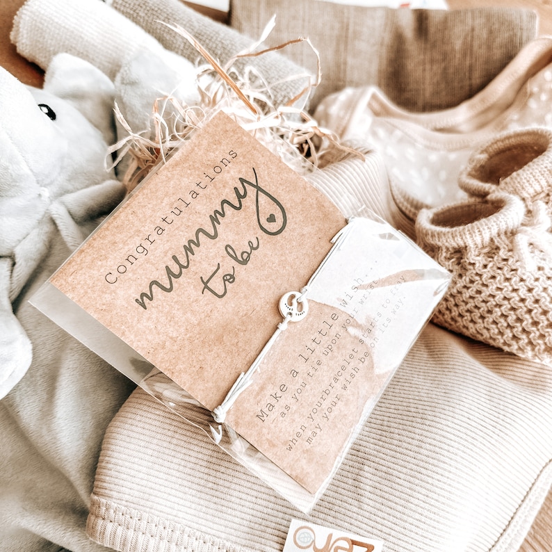 May include: A gift basket for a new mom with a card that says "Congratulations Mummy to be" and a bracelet with a charm that says "Make a little wish... as you tie upon your wrist when your bracelet starts to may your wish be on its way."