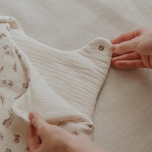 May include: A white baby onesie with a floral print and a snap closure. The onesie is made of a soft, breathable fabric and is perfect for keeping baby comfortable and stylish.