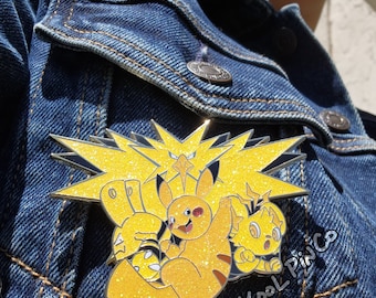 May include: A yellow glitter enamel pin featuring three Pokemon characters: Pikachu, Pichu, and Raichu. The pin is set against a black background with a yellow lightning bolt design. The text "Kool PinCo" is written in white on the bottom right corner of the pin.