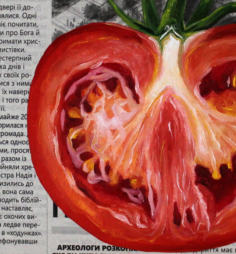 May include: A close-up of a red tomato cut in half, showing the inside with seeds and a white core. The tomato is on a newspaper background.