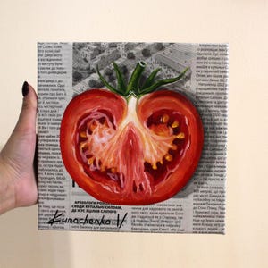 May include: A painting of a red tomato cut in half, with the seeds and flesh visible. The tomato is painted on a newspaper background with text in Russian.
