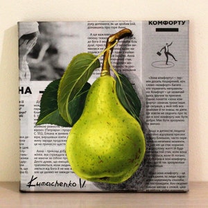 May include: A square canvas painting featuring a realistic green pear with two dark green leaves and a brown stem, layered over a background of black and white newspaper print in Ukrainian text, with the artist signature Kumachenko V. at the bottom.