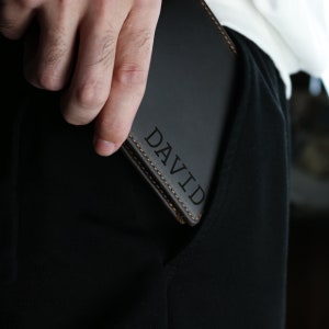 May include: A black leather wallet with the name 'DAVID' embossed in gold lettering.