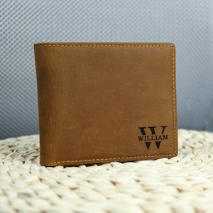 May include: A brown leather wallet with the name 'WILLIAM' and the letter 'W' embossed on the front.