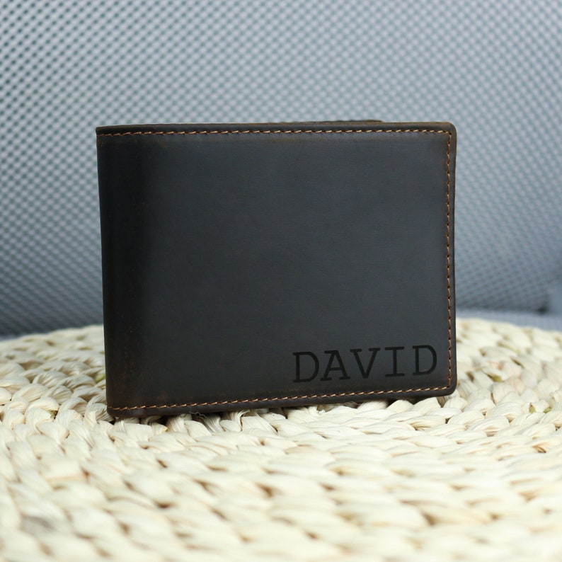 May include: A brown leather wallet with the name 'DAVID' embossed on the front.