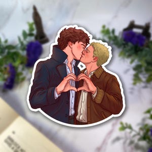May include: A die-cut sticker featuring a digital illustration of two individuals kissing. One person has curly brown hair and wears a dark blue coat over a white shirt. The other has short blonde hair and wears a brown jacket over a white shirt.