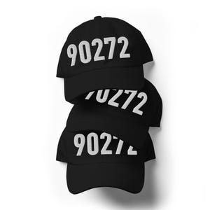 Op de afbeelding: Een stapel van drie zwarte baseballpetten, elk voorzien van het wit geborduurde nummer 90272 op het voorpaneel. De petten hebben een gestructureerde kroon, een gebogen klep en een klassiek ontwerp met zes panelen en bijpassende zwarte stiksels.