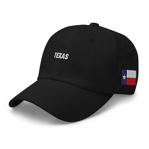 Peut inclure: Casquette de baseball noire avec le mot "TEXAS" brodé en blanc sur le devant. Le drapeau de l'État du Texas est brodé sur le côté. La casquette a une visière incurvée et une sangle réglable.