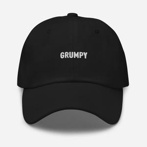 May include: A black baseball cap with white embroidered text that reads "GRUMPY".