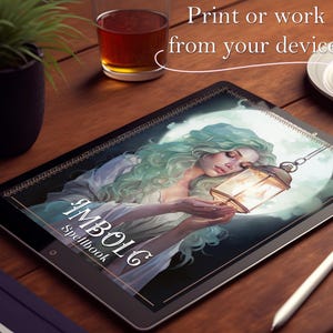 Puede incluir: Una tableta digital que muestra la portada de un libro con una mujer sosteniendo una linterna. La portada presenta el t&iacute;tulo "IMBOLC Spellbook" en una fuente decorativa.
