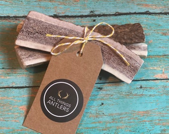 May include: Two antler chews tied together with twine and a brown paper tag with a black circle logo that says "All Things Antlers".