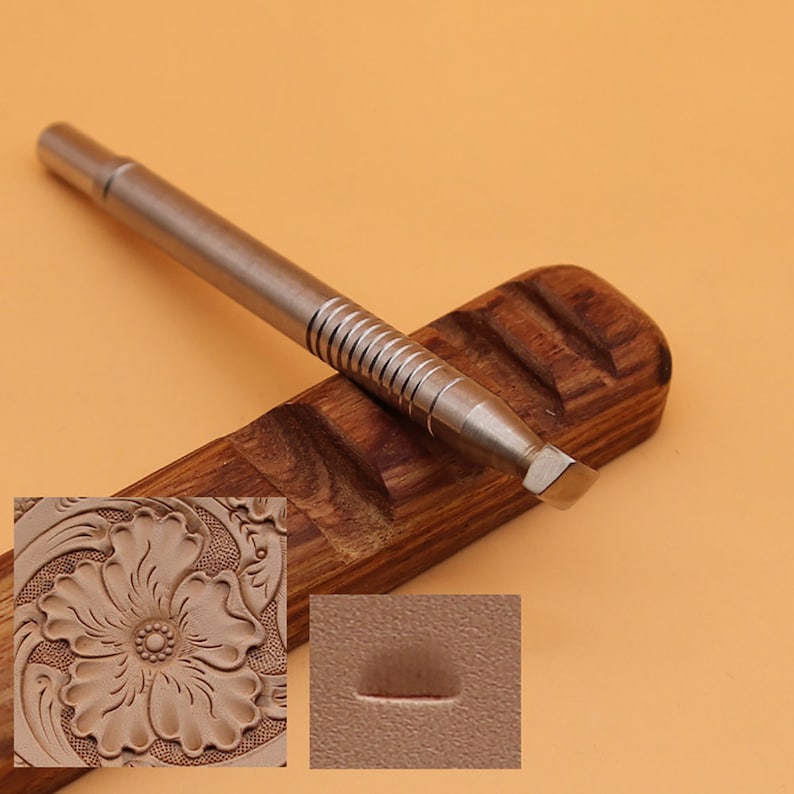 May include: A metal leathercraft tool with a ridged handle and angled blade rests on a wooden holder. The image includes a close-up of a floral leather carving and a sample impression, showcasing the tool's potential for detailed work.