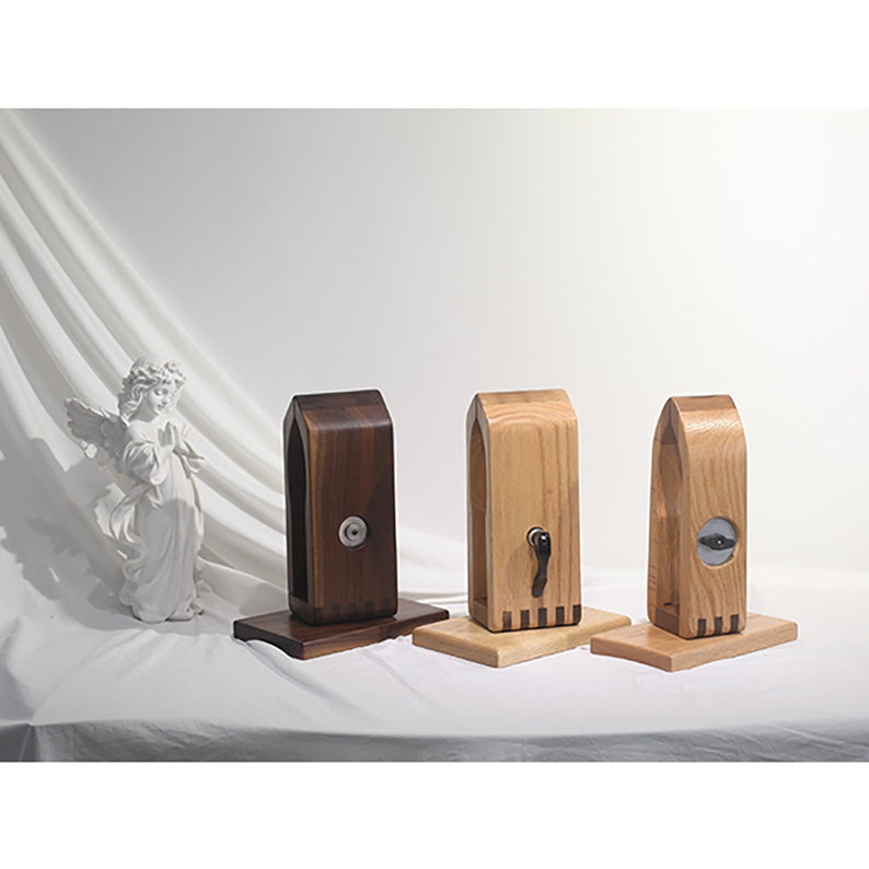Puede incluir: Tres soportes para auriculares de madera, uno marr&oacute;n oscuro, uno marr&oacute;n claro y uno marr&oacute;n medio. Cada soporte tiene una peque&ntilde;a perilla de metal en la parte delantera.