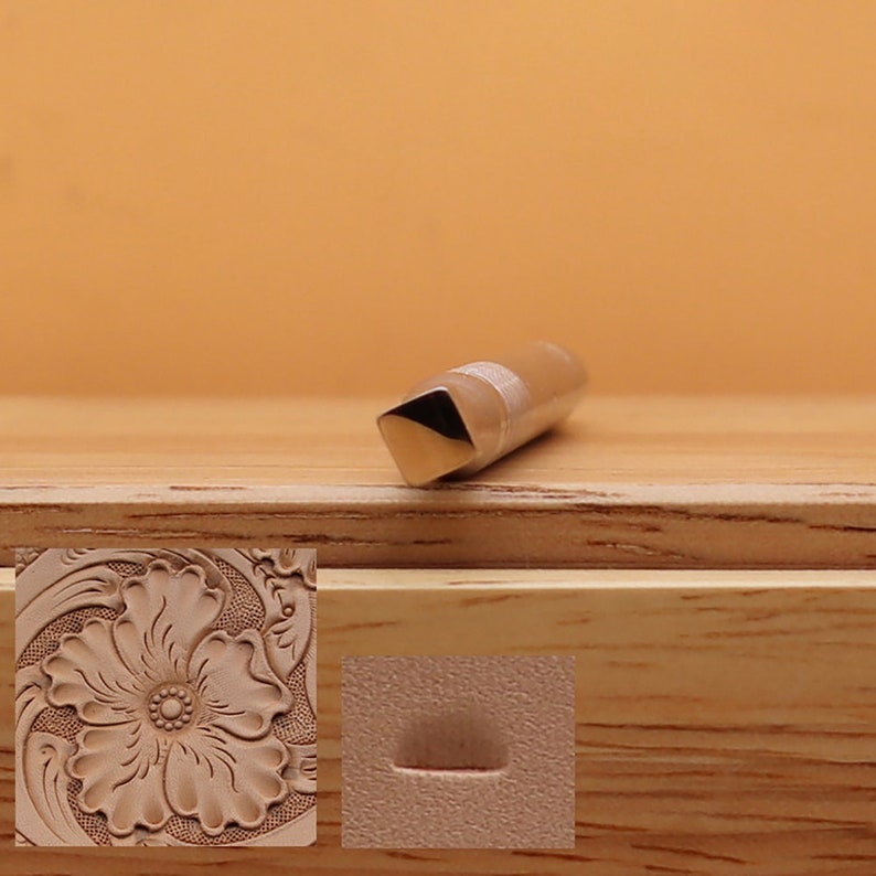 May include: A metal leathercraft tool with a square end and a cylindrical body. The tool is designed for creating decorative patterns on leather. The image also shows a sample of a floral design and a curved line created with the tool.