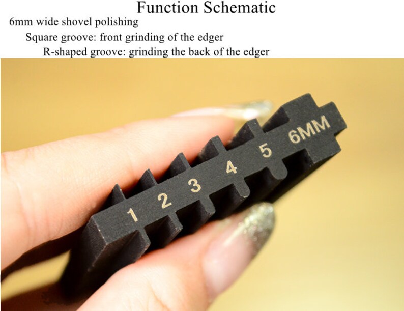 May include: A black tool with six grooves, each labeled with a number from 1 to 6. The last groove is labeled "6MM".