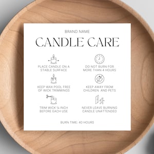 May include: A white card with candle care instructions, including "Place candle on a stable surface," and "Do not burn for more than 4 hours." The card is on a wooden plate.