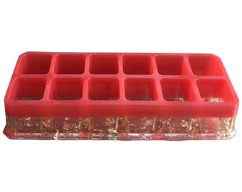 May include: Red organizer with 12 compartments, made of clear resin with gold flakes embedded in the base.
