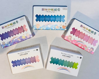 May include: Five packs of colorful washi tape with a rainbow and cartoon characters on the packaging. Each pack contains six pieces of tape and is labeled "Masking Tape" and "Northern Europe".