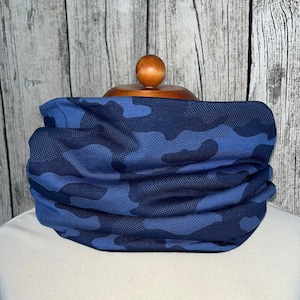 May include: A blue and black camouflage patterned neck warmer. The neck warmer is made of a soft, stretchy fabric and is perfect for keeping warm in the winter.