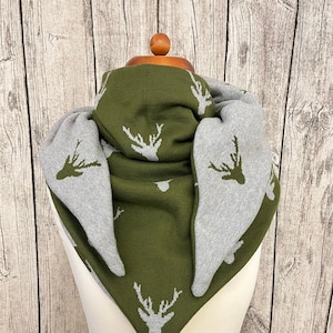 May include: A triangular scarf with a reversible design. One side is olive green with a white deer print, and the other side is gray with a white deer print.