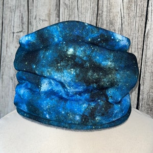 May include: A blue and black galaxy print neck warmer. The fabric is soft and stretchy.