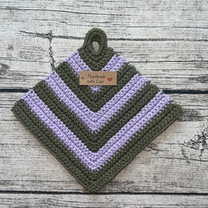 Könnte beinhalten: Ein grüner und lila gehäkelter Topflappen mit einem braunen Etikett, auf dem "Handmade with Love" steht.
